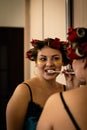 Beautiful brunette in home pajamas and curlers brushes her teeth near the mirror Royalty Free Stock Photo