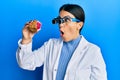 Beautiful brunette jeweller woman holding geode stone wearing magnifier glasses afraid and shocked with surprise and amazed