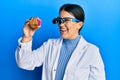 Beautiful brunette jeweller woman holding geode stone wearing magnifier glasses smiling with a happy and cool smile on face