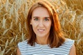 Beautiful brunette lady in wheat field at sunset. Pretty smiling young woman against the background of rye ears Royalty Free Stock Photo