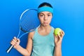 Beautiful brunette little girl playing tennis holding racket and ball depressed and worry for distress, crying angry and afraid Royalty Free Stock Photo