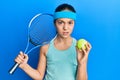 Beautiful brunette little girl playing tennis holding racket and ball skeptic and nervous, frowning upset because of problem Royalty Free Stock Photo