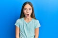 Beautiful brunette little girl wearing casual white t shirt afraid and shocked with surprise expression, fear and excited face Royalty Free Stock Photo