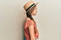 Beautiful brunette little girl wearing summer hat looking to side, relax profile pose with natural face with confident smile Royalty Free Stock Photo