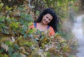 A beautiful brunette with long curly hair in a shiny autumnal path