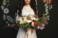 Beautiful brunette model woman with stylish hairstyle in the stylish lace dress holding a big luxury bouquet of exotic Royalty Free Stock Photo