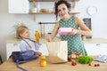 Beautiful brunette mother and her daughter packing healthy lunch and preparing school bag Royalty Free Stock Photo