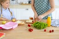 Beautiful brunette mother and her daughter packing healthy lunch and preparing school bag Royalty Free Stock Photo