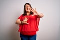 Beautiful brunette plus size woman wearing casual red t-shirt over isolated white background afraid and terrified with fear Royalty Free Stock Photo