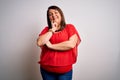 Beautiful brunette plus size woman wearing casual red t-shirt over isolated white background looking confident at the camera Royalty Free Stock Photo