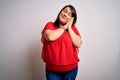 Beautiful brunette plus size woman wearing casual red t-shirt over isolated white background sleeping tired dreaming and posing Royalty Free Stock Photo