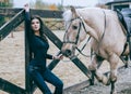 Beautiful brunette posing with a horse in the autumn afternoon at a country ranch. Lifestyle Photo. Fashion photo. Horseback ridin Royalty Free Stock Photo