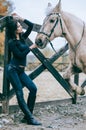 Beautiful brunette posing with a horse in the autumn afternoon at a country ranch. Lifestyle Photo. Fashion photo. Horseback ridin Royalty Free Stock Photo