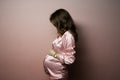 Beautiful brunette pregnant model in pink suit on pink background