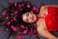 Beautiful brunette with rose petals in her hair Royalty Free Stock Photo