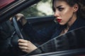 Beautiful brunette sexy spy agent killer or police woman in leather jacket and jeans with a gun in her hand driving a car after Royalty Free Stock Photo
