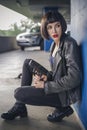 Beautiful brunette sexy spy agent killer or police woman in leather jacket and jeans with a gun in her hand running after Royalty Free Stock Photo