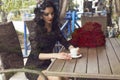 beautiful brunette sitting in city cafe with cup of coffee Royalty Free Stock Photo