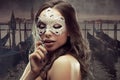 Beautiful brunette with Venetian mask. Young and beautiful woman on Venetian view background, gondolas. Royalty Free Stock Photo