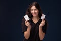 Curly hair brunette is posing with playing cards in her hands. Poker concept on a black background. Casino. Royalty Free Stock Photo