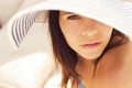 Beautiful brunette woman on the beach alone relaxing in a hat. S Royalty Free Stock Photo