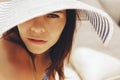 Beautiful brunette woman on the beach alone relaxing in a hat. Summer. Outdoors. Copy space Royalty Free Stock Photo