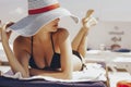 Beautiful brunette woman on the beach in pool alone relaxing in swimsuit and hat. Summer. Outdoors. copy space Royalty Free Stock Photo