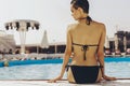 Beautiful brunette woman on the beach in pool alone relaxing in swimsuit. Summer. Outdoors. copy space Royalty Free Stock Photo