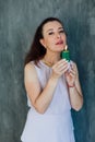 brunette woman blowing out a burning green candle