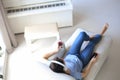 Beautiful brunette woman in earphones sitting on sofa listening to music with closed eyes, drinking red wine. Royalty Free Stock Photo