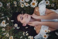 Beautiful brunette woman is enjoying spring in a field of daisies Royalty Free Stock Photo