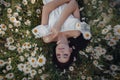 Beautiful brunette woman is enjoying spring in a field of daisies Royalty Free Stock Photo