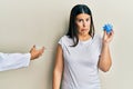 Beautiful brunette woman getting vaccine holding coronavirus toy depressed and worry for distress, crying angry and afraid