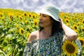 Beautiful brunette woman with hat in sunflower field Royalty Free Stock Photo
