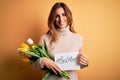 Beautiful brunette woman holding best mom message and tulips celebrating mothers day with a happy face standing and smiling with a Royalty Free Stock Photo