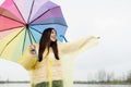 Beautiful brunette woman holding colorful umbrella out in the rain Royalty Free Stock Photo