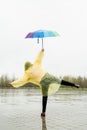 Beautiful brunette woman holding colorful umbrella out in the rain Royalty Free Stock Photo