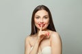 Beautiful brunette woman holding finger near lips. Secret and silence concept