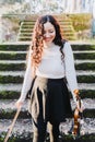 Beautiful brunette woman laughing holding a violin and a bow, going down stairs Royalty Free Stock Photo