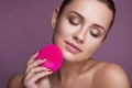 Beautiful brunette woman massage her face with a beauty massager. Her skin fresh, clean and flawless. Spa procedure concept Royalty Free Stock Photo