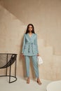Beautiful brunette woman natural make up wear fashion clothes casual dress code office style blue jacket and pants suit for