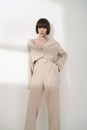 Beautiful brunette with graphic bob haircut wear beige fashion pantsuit Royalty Free Stock Photo