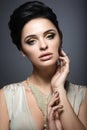 Beautiful brunette woman with perfect skin, gold makeup and handmade jewelry. Beauty face.