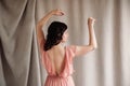 Beautiful brunette woman in a pink dress on a background of linen fabric. Copy, empty space for text Royalty Free Stock Photo
