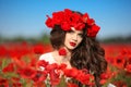 Beautiful brunette woman in poppies field with flowers, attractive teen girl. Beauty outdoor model with red lips portrait.