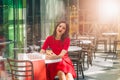 Beautiful brunette woman in red dress drinking coffee in a coffee shop Royalty Free Stock Photo