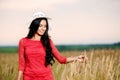 Beautiful brunette woman with a red dress in a field Royalty Free Stock Photo