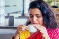 Beautiful brunette woman in red sari eating with appetite traditional thali with rise,curd,dal in Goa restaurant and Royalty Free Stock Photo