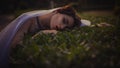 Beautiful brunette woman sleeping in a grass and flowers in the Royalty Free Stock Photo