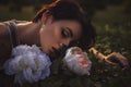 Beautiful brunette woman sleeping in a grass and flowers in the Royalty Free Stock Photo